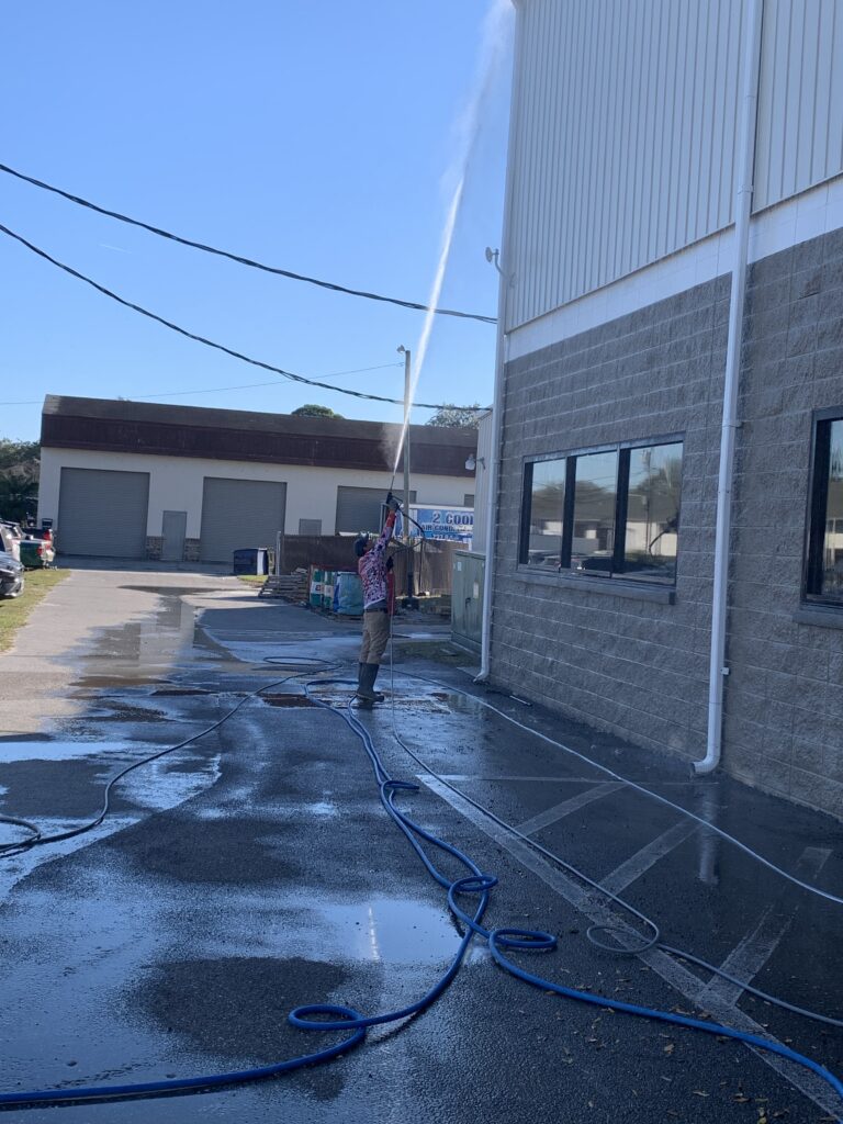 Innovative Pressure Washing Technician power washing the outside of a commercial property in Florida